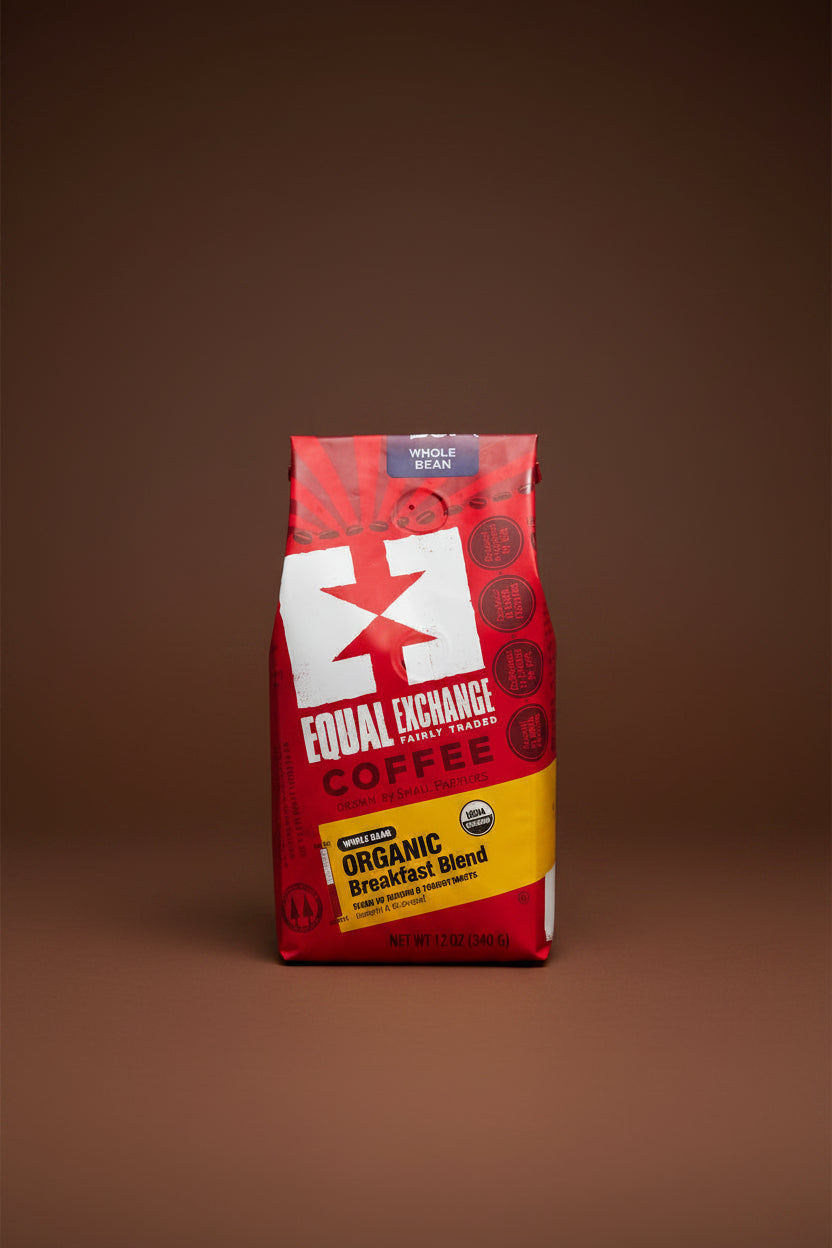 A 12 oz bag of Equal Exchange Fairly Traded Organic Breakfast Blend coffee, featuring a red and yellow packaging design with a large white logo.